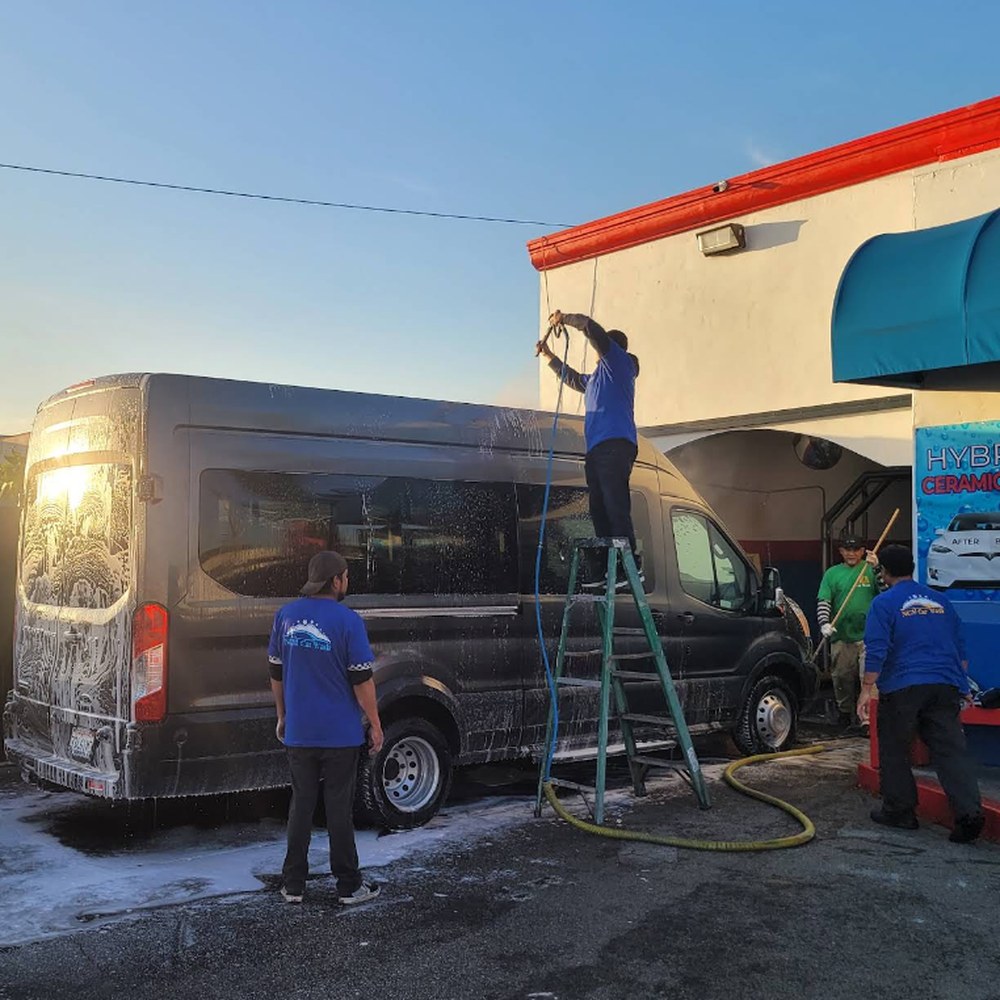 SuperKleen team hand washing a large Sprinter van with foam